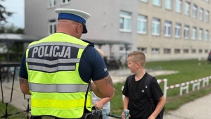 Policjant wręcza dzieciom odblaski