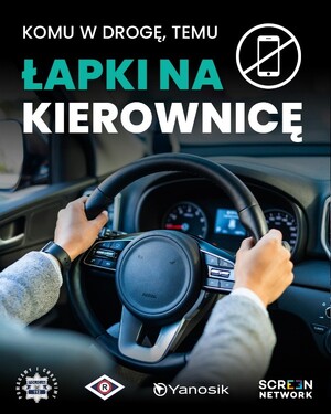 plakat z kampanią i hasłem " Łapki na kierownicę" przedstawiający kierownicę z rękoma na kierownicę.