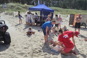 Sześć zdjęć przedstawiających działania na plaży - policjant w grantantowym mundurze, strażak w mundurze i przedstawiciele Wodnego Ochotniczego Pogotowia Rarunkowego, w tle dzieci i namiot profilaktyczny,