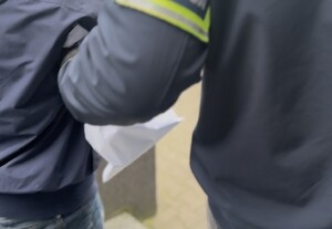 ręka policjanta, z opaską z napisem policja