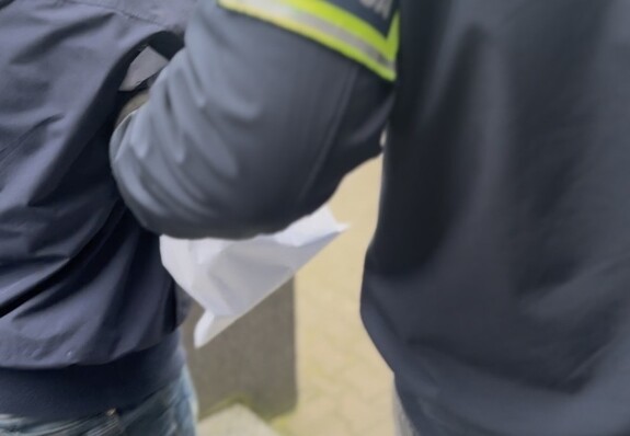 ręka policjanta, z opaską z napisem policja