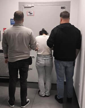 policjanci prowadzą jedną z zatrzymanych osób